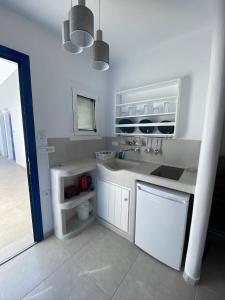 a white bathroom with a sink and a toilet at Nikoletta Studios in Agios Prokopios