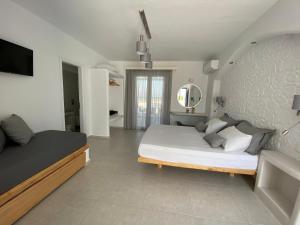een slaapkamer met twee bedden en een spiegel bij Nikoletta Studios in Agios Prokopios +83 foto's