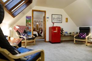 a living room with a red refrigerator and chairs at Ceol na Mara Guest House in Tarbert