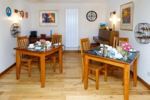 a dining room with two tables and chairs at Ceol na Mara Guest House in Tarbert