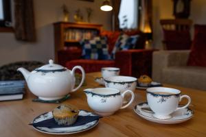 a table with three tea cups and a muffin on them at Ceol na Mara Guest House in Tarbert