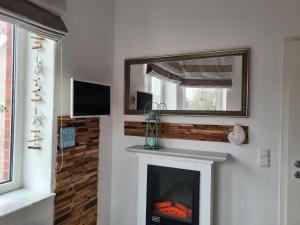 ein Wohnzimmer mit einem Kamin und einem Spiegel in der Unterkunft Ferienwohnung BEACHHOUSE in Cuxhaven