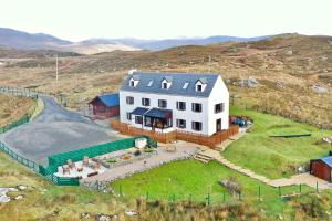 an aerial view of a large white house on a hill at Ceol na Mara Guest House in Tarbert