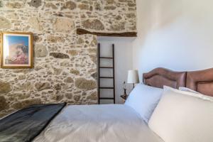 a bed in a room with a stone wall at Stonehouse South Crete in Vóroi