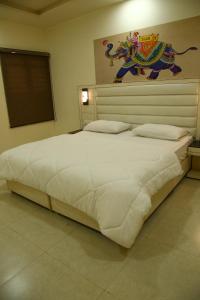 a large white bed in a bedroom with a painting on the wall at Villa 21 Agra in Agra