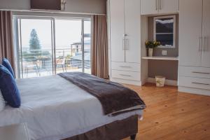 a bedroom with a bed and a large window at Harbour Lights Luxury Loft in Port Elizabeth