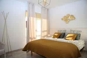 een slaapkamer met een bed met gele kussens bij T3 tout confort PLAGE A 20 METRES in Saint-Cyr-sur-Mer