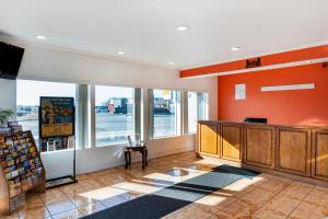 a store lobby with orange walls and windows at OYO Townhouse Dodge City KS in Dodge City