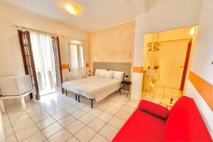 a bedroom with a bed and a red couch at Albergo Vittoria in Toscolano Maderno