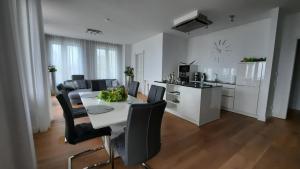ein Wohnzimmer mit einem Tisch und Stühlen sowie eine Küche in der Unterkunft Viktoria Deluxe direkter Meerblick in Ostseebad Sellin