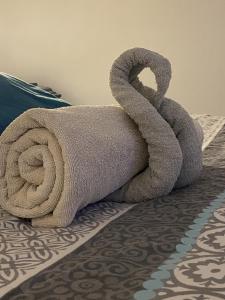 a towel that looks like a towel snake on a bed at Adorable Gesthouse avec parking gratuit sur place. in Le Chêne