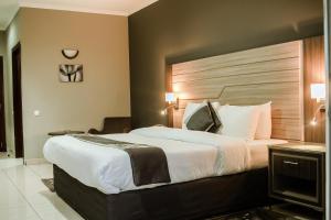 a bedroom with a large bed with a wooden headboard at Hotel Milenio in Nampula