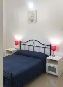 a bedroom with a blue bed and two tables with lamps at Home From Home in Nugegoda