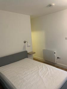 a bedroom with a white bed and a radiator at Room 3 Camp Street B&B in Oughterard