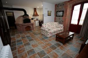 a living room with a couch and a brick fireplace at Casa Josefita in Villamayor