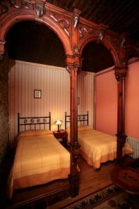 two beds in a bedroom with an archway at Casa Josefita in Villamayor