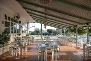a restaurant with tables and chairs on a patio at Elafonisi Resort by Kalomirakis Family in Elafonisi