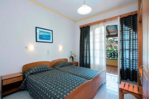 ein Schlafzimmer mit einem großen Bett und einem Fenster in der Unterkunft Andreas Pool Complex in Korfu-Stadt