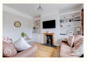 - un salon avec un canapé et une cheminée dans l'établissement Charming 3-Bed Cottage in Swanage, à Swanage