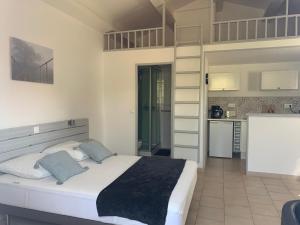 1 dormitorio con 1 cama blanca grande y cocina en L'APARTE - Studio Les AMANDIERS, en Pignans