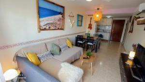een woonkamer met een bank en een tafel bij LA PITA- Terraza con vistas al mar & parking, a 1 min de la playa in Carboneras