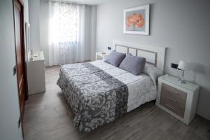 Un dormitorio con una cama y una cómoda y una ventana. en Apartamentos Maquinista, en Puente Genil