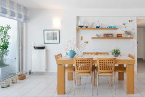 comedor con mesa de madera y sillas en Beachfront Modern Apartment, en Eretria