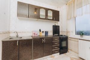 a kitchen with a sink and a stove at Apartments Illinskaya 8 floor 2 room in Sumy