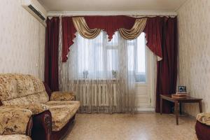a living room with a couch and a large window at Apartments Illinskaya 8 floor 2 room in Sumy