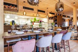 una mesa grande en un restaurante con sillas rosas y blancas en Bergwaldsuites, en Schierke