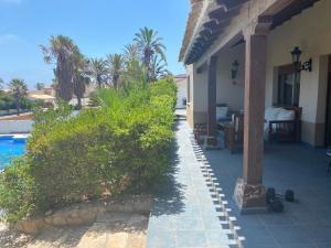 un porche de una casa con piscina en Chalet 5 dormitorios con piscina y jardín, en La Manga del Mar Menor