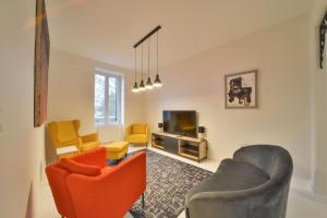 a living room with two chairs and a tv at La Maison d'Hestia in Vierzon