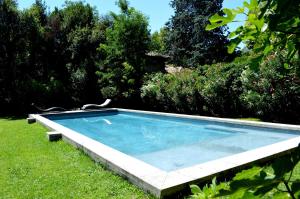 a swimming pool in the grass in a yard at LA MAISON CIARA - Suites et chambres in Orange