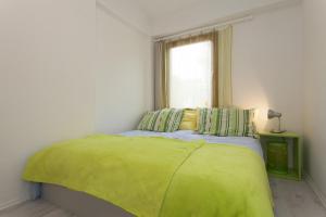 sypialnia z zielonym łóżkiem i oknem w obiekcie APARTMENT Buena Vista Borik w Rovinj