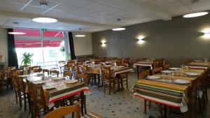 a dining room filled with tables and chairs at Hôtel de L'Europe in Gramat