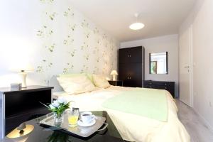sypialnia z łóżkiem i stołem z kwiatami w obiekcie APARTMENT Buena Vista Borik w Rovinj
