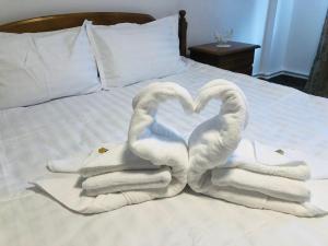 two swans making a heart shape on a bed at Mireasma Bucovinei Apartment in Crucea