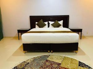 a bedroom with a large bed with two night stands at Arrawiya Alzahabia Hotel in Dammam
