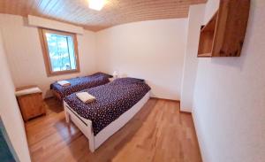 - une chambre avec 2 lits et une fenêtre dans l'établissement Bel Air C, à Champéry