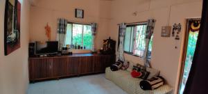 a living room with a couch and a tv at Cheerful Villa at Chaul Alibag Near Revdanda and Nagav Beach in Alibaug
