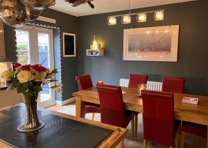 ein Esszimmer mit einem Tisch und roten Stühlen in der Unterkunft Clocktower Suite in Exeter