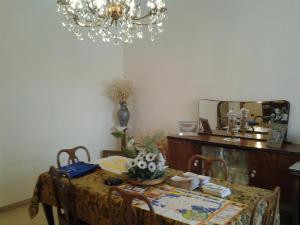 a dining room table with a mirror and a chandelier at B&BGalatina1 CIS in Galatina