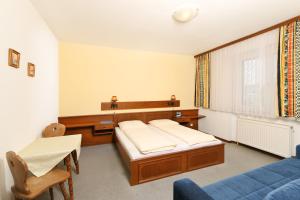 1 Schlafzimmer mit 2 Betten, einem Tisch und einem Fenster in der Unterkunft Gasthof-Pension Wein in Breitenbrunn