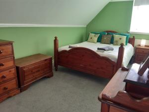 a bedroom with a wooden bed and a dresser at Carvetii - Halite House - 3 bed House sleeps up to 5 people in Tillicoultry