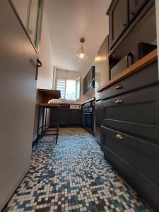 eine Küche mit Fliesenboden und einem Tisch in der Unterkunft Bel appartement 2 pièces, sortie de métro ligne 8 in Charenton-le-Pont