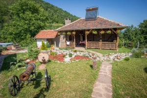 a small house with a gazebo in a yard at Seosko domaćinstvo „GABAR” in Ćuštica