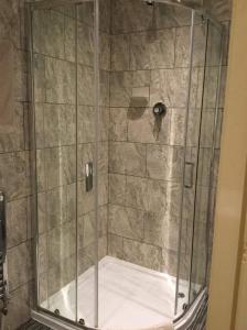 
a shower stall with a glass shower door at The Libra in Blackpool
