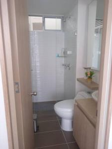 La salle de bains est pourvue d'une douche et de toilettes blanches. dans l'établissement Apartamento ideal para disfrutar Vacaciones en Ricaurte Cund, à Ricaurte