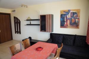 a living room with a red table and a couch at Apartments Paskalina in Byala