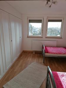 a bedroom with a bed and two windows at Ferienwohnung Yara Rödental in Rödental